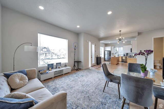 869 S Washington St Unit 101, Salt Lake City, UT 84101 - living area featuring recessed lighting, a textured ceiling, and an inviting chandelier