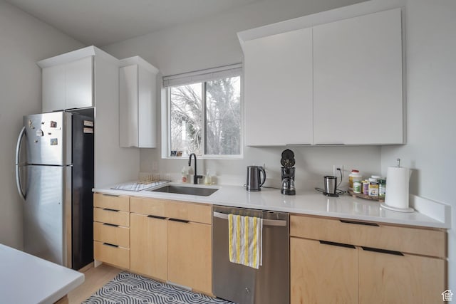 869 S Washington St Unit 101, Salt Lake City, UT 84101 - kitchen featuring light wood-style flooring, light brown cabinetry, a sink, stainless steel appliances, and light countertops