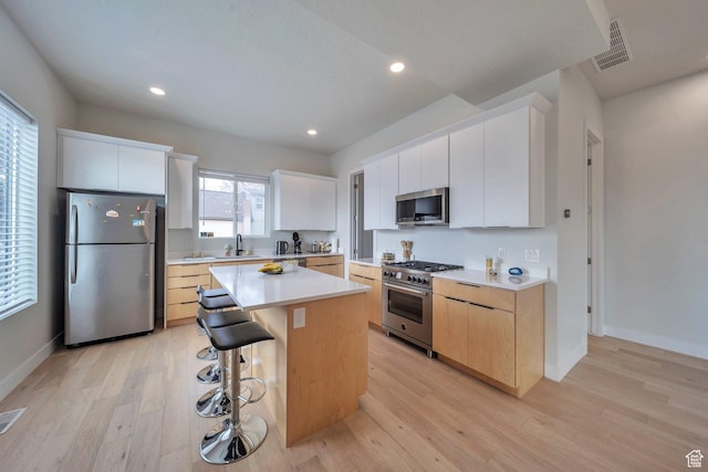 869 S Washington St Unit 101, Salt Lake City, UT 84101 - kitchen featuring light wood-style floors, visible vents, appliances with stainless steel finishes, and a sink