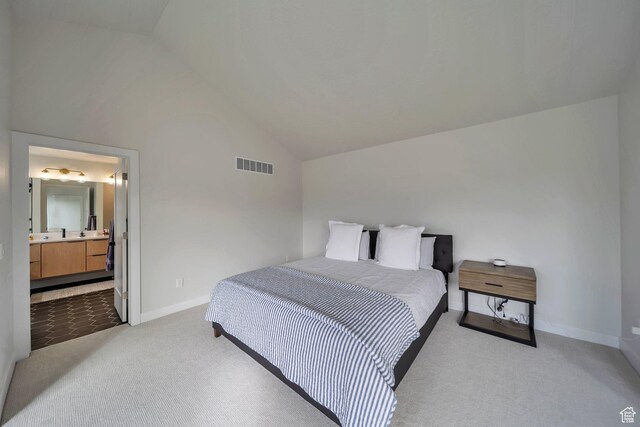 869 S Washington St Unit 101, Salt Lake City, UT 84101 - bedroom with visible vents, baseboards, ensuite bath, lofted ceiling, and light colored carpet