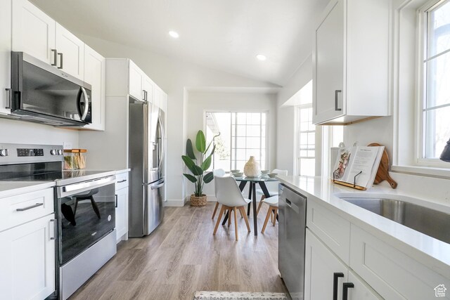 865 W 1800 N, Mapleton, UT 84664 - kitchen featuring light wood finished floors, a sink, stainless steel appliances, vaulted ceiling, and white cabinets