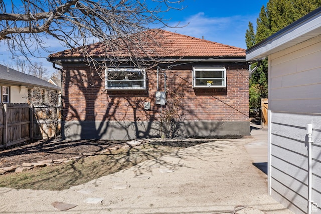 1444 E Sherman Ave, Salt Lake City, UT 84105 - view of property exterior featuring a tile roof, brick siding, and fence