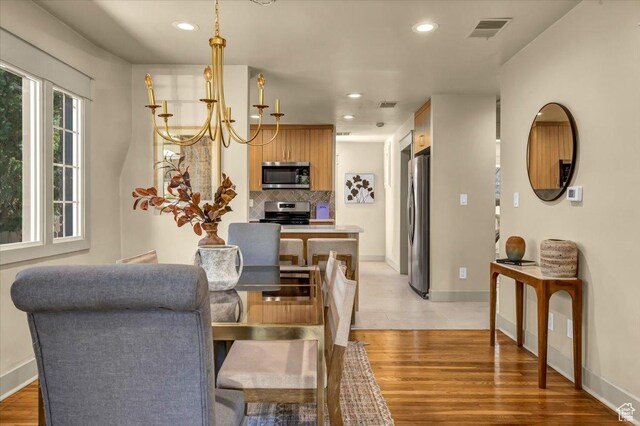 1444 E Sherman Ave, Salt Lake City, UT 84105 - dining room featuring baseboards, visible vents, light wood-style flooring, and a chandelier