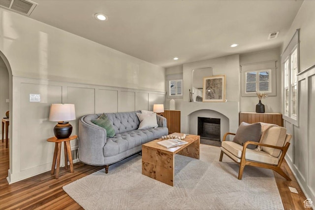 1444 E Sherman Ave, Salt Lake City, UT 84105 - living area with arched walkways, a fireplace, visible vents, and wood finished floors