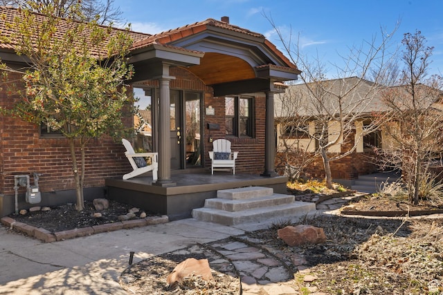 1444 E Sherman Ave, Salt Lake City, UT 84105 - doorway to property with covered porch, a tiled roof, and brick siding