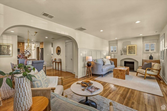 1444 E Sherman Ave, Salt Lake City, UT 84105 - living room featuring an inviting chandelier, wood finished floors, arched walkways, and visible vents
