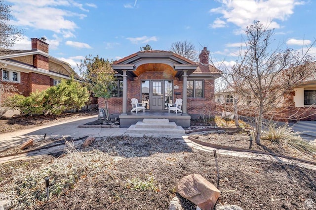 1444 E Sherman Ave, Salt Lake City, UT 84105 - rear view of property featuring a chimney, a tiled roof, french doors, and brick siding