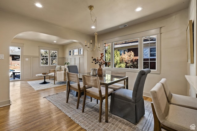 1444 E Sherman Ave, Salt Lake City, UT 84105 - dining room with visible vents, wood finished floors, arched walkways, and a decorative wall