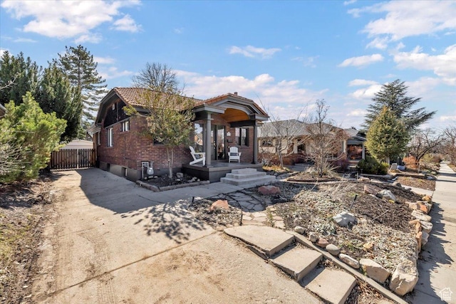 1444 E Sherman Ave, Salt Lake City, UT 84105 - view of front of house with a tiled roof, brick siding, driveway, and fence