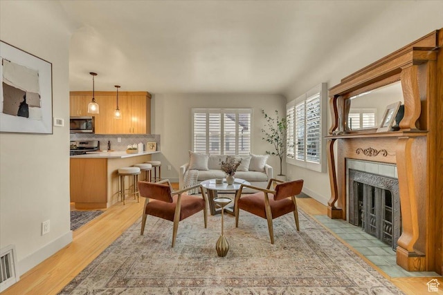 1662 E Browning Ave, Salt Lake City, UT 84105 - living area featuring visible vents, a tile fireplace, baseboards, and light wood-style floors