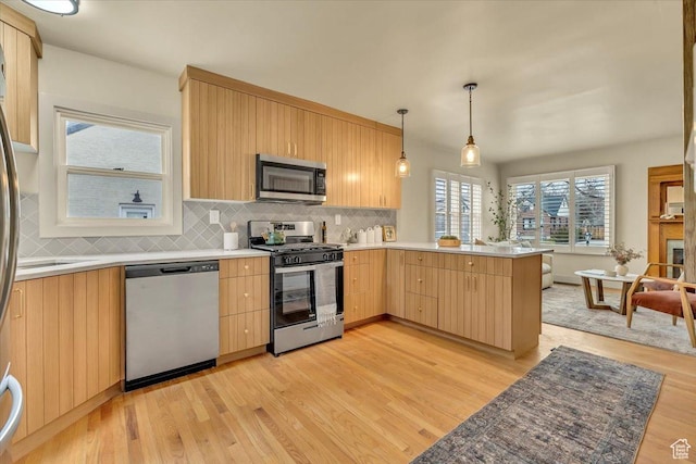 1662 E Browning Ave, Salt Lake City, UT 84105 - kitchen featuring a peninsula, light wood-style floors, light brown cabinetry, and stainless steel appliances