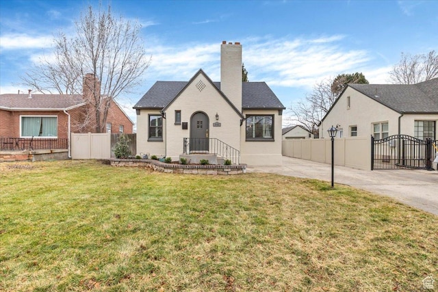 view of front of property with a front lawn, a gate, fence, and a chimney
