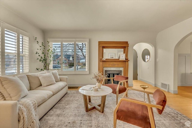 1662 E Browning Ave, Salt Lake City, UT 84105 - living area with visible vents, baseboards, a fireplace, wood finished floors, and arched walkways