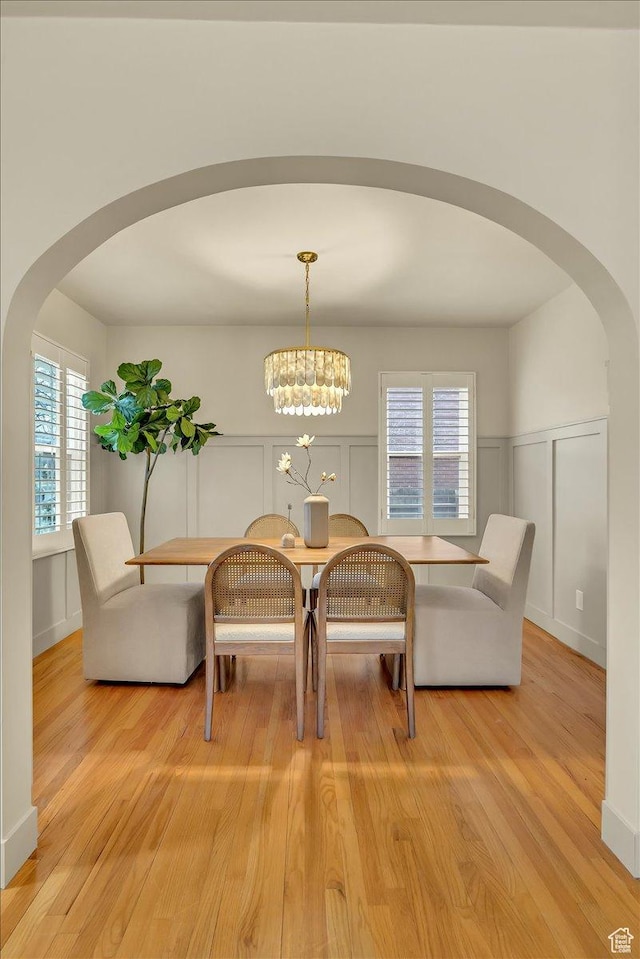 1662 E Browning Ave, Salt Lake City, UT 84105 - dining area featuring light wood-type flooring, arched walkways, and a decorative wall