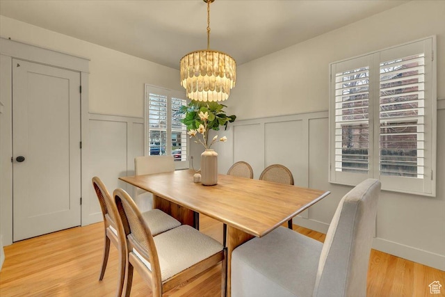 1662 E Browning Ave, Salt Lake City, UT 84105 - dining space featuring a decorative wall, a chandelier, wainscoting, and light wood finished floors