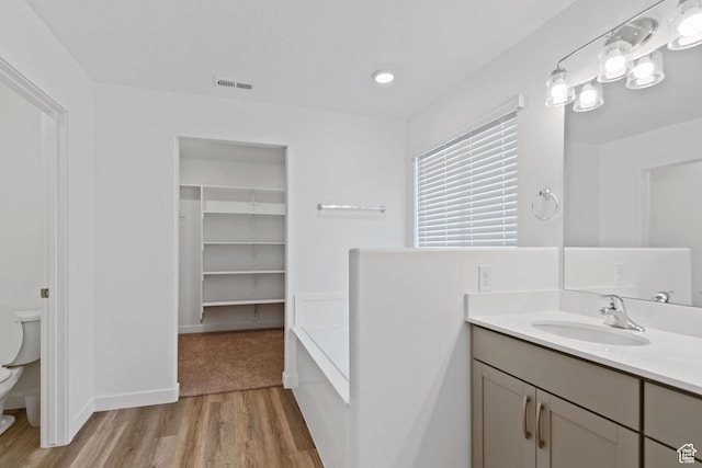2256 E Emerald Ave Unit 208, Eagle Mountain, UT 84005 - full bath featuring visible vents, toilet, a bathing tub, wood finished floors, and vanity