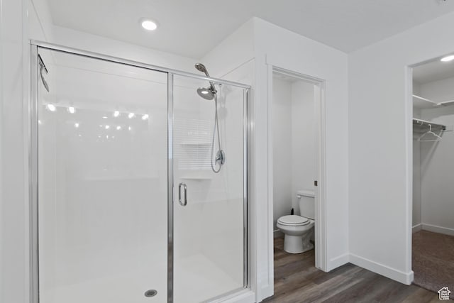 2256 E Emerald Ave Unit 208, Eagle Mountain, UT 84005 - bathroom featuring a spacious closet, a stall shower, toilet, and wood finished floors