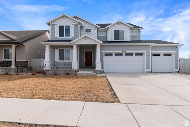 craftsman-style home featuring driveway, an attached garage, and fence