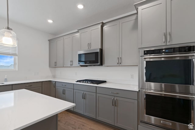 2256 E Emerald Ave Unit 208, Eagle Mountain, UT 84005 - kitchen with gray cabinets, wood finished floors, recessed lighting, appliances with stainless steel finishes, and light countertops
