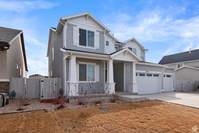 2256 E Emerald Ave Unit 208, Eagle Mountain, UT 84005 - view of front facade featuring a gate, fence, driveway, an attached garage, and covered porch