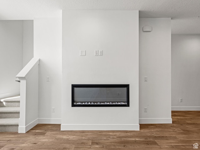 1151 Gambel Oak Way Unit 54, Park City, UT 84098 - details with a glass covered fireplace, a textured ceiling, baseboards, and wood finished floors