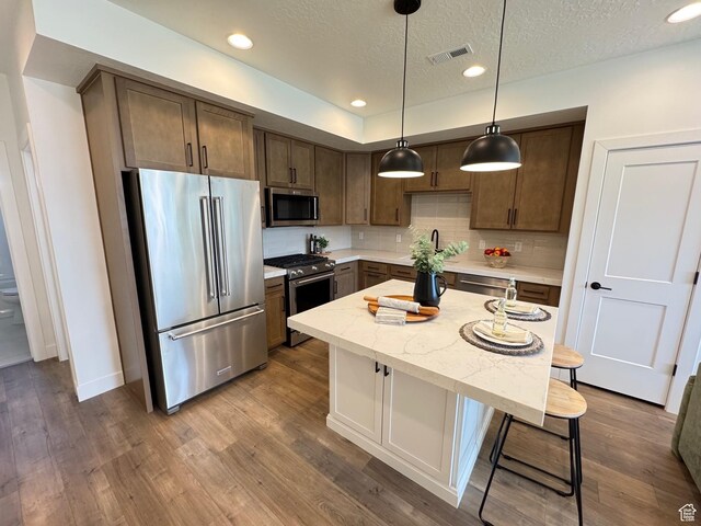 1151 Gambel Oak Way Unit 54, Park City, UT 84098 - kitchen featuring stainless steel appliances, a breakfast bar, decorative backsplash, dark wood-style flooring, and recessed lighting