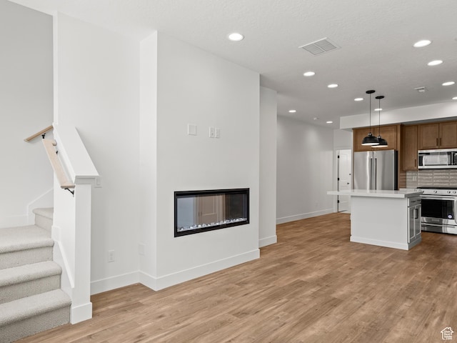 1151 Gambel Oak Way Unit 54, Park City, UT 84098 - unfurnished living room with a glass covered fireplace, recessed lighting, visible vents, and light wood-type flooring