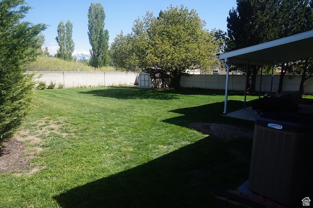 6835 S Larabrook Way, West Jordan, UT 84084 - view of yard with cooling unit, an outbuilding, a shed, and a fenced backyard