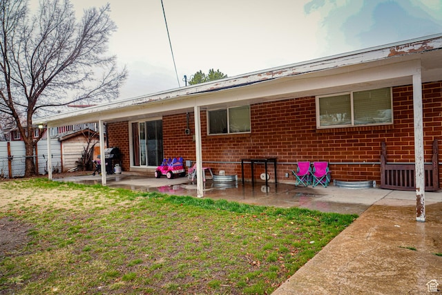 1993 W 4200 S, Roy, UT 84067 - rear view of property featuring a yard, a patio, brick siding, and fence