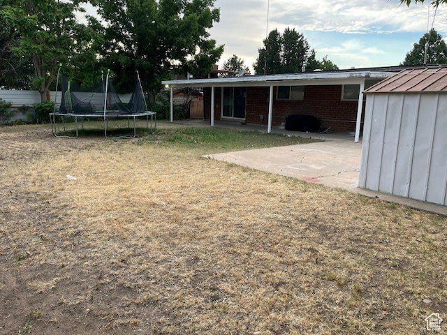 1993 W 4200 S, Roy, UT 84067 - view of green lawn featuring a trampoline, a patio area, and a shed