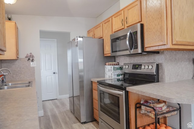 1993 W 4200 S, Roy, UT 84067 - kitchen with light brown cabinets, light countertops, light wood-style flooring, stainless steel appliances, and a sink