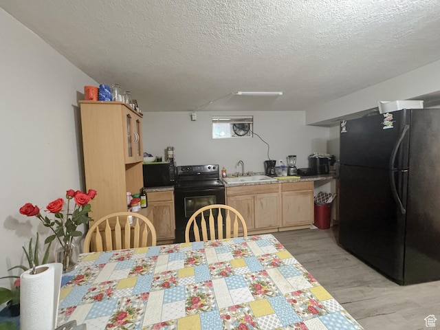 1993 W 4200 S, Roy, UT 84067 - kitchen featuring black appliances, light brown cabinetry, a sink, light wood-style floors, and light countertops