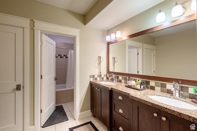 bathroom with tile patterned flooring, backsplash, double vanity, and a sink