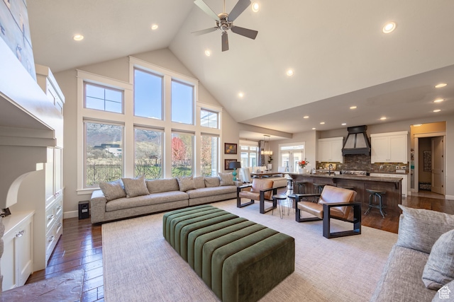 living area with recessed lighting, a ceiling fan, light wood finished floors, and high vaulted ceiling