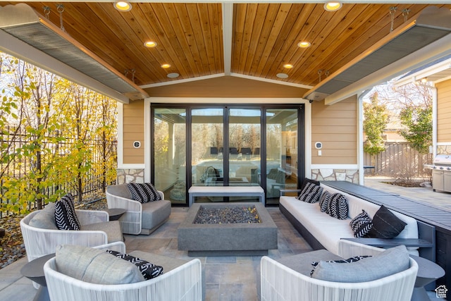 view of patio featuring an outdoor living space with a fire pit and fence