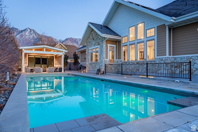 view of pool with a patio, a fenced in pool, and a mountain view