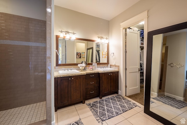 full bath featuring tile patterned flooring, double vanity, a walk in shower, and a sink