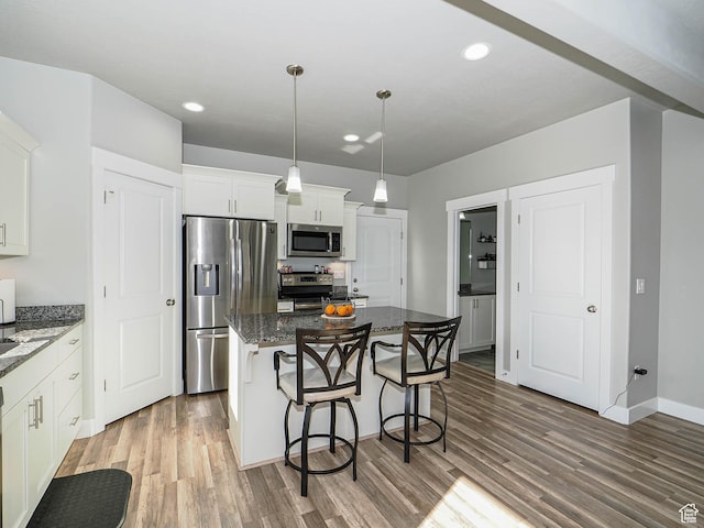 3765 E Cunninghill Dr, Eagle Mountain, UT 84005 - kitchen featuring a kitchen island, light wood-type flooring, a kitchen breakfast bar, stainless steel appliances, and white cabinetry