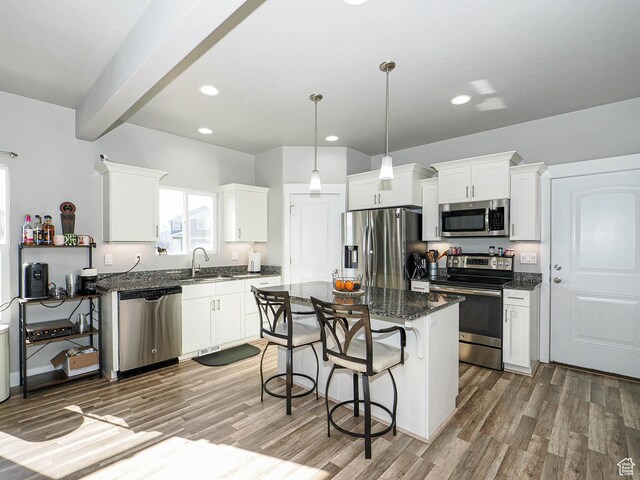 3765 E Cunninghill Dr, Eagle Mountain, UT 84005 - kitchen with a kitchen bar, appliances with stainless steel finishes, white cabinets, and light wood-style flooring