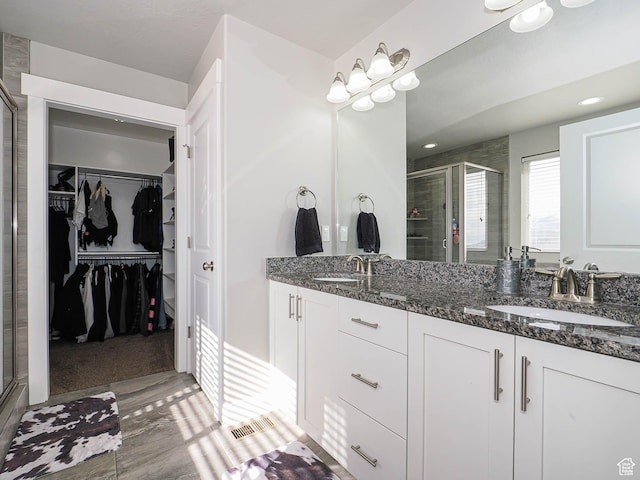 3765 E Cunninghill Dr, Eagle Mountain, UT 84005 - bathroom featuring a spacious closet, a shower stall, and a sink