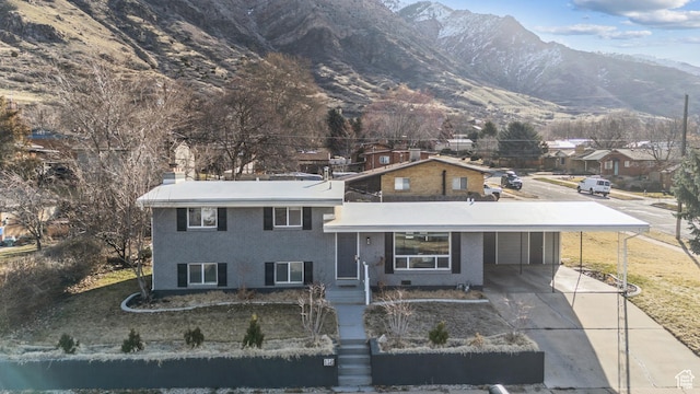 118 N Iowa Ave, Ogden, UT 84404 - split level home with a mountain view, an attached carport, concrete driveway, and a chimney