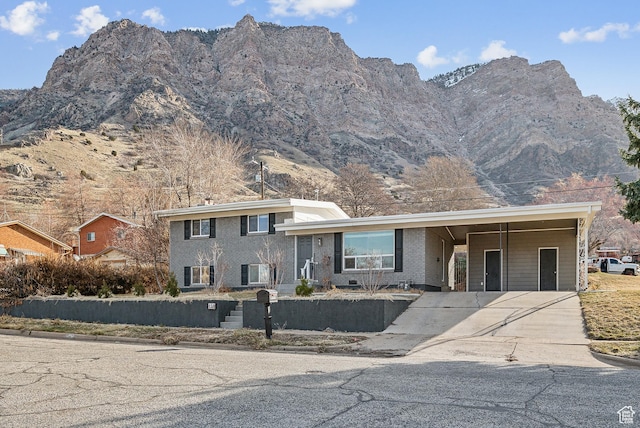 118 N Iowa Ave, Ogden, UT 84404 - tri-level home featuring a carport, a mountain view, concrete driveway, and brick siding