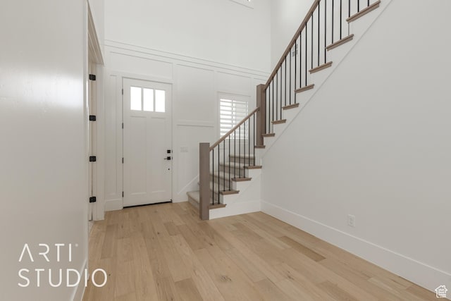 3823 S Kennedy Ln, Washington, UT 84780 - entryway with wood finished floors, a high ceiling, a decorative wall, baseboards, and stairs