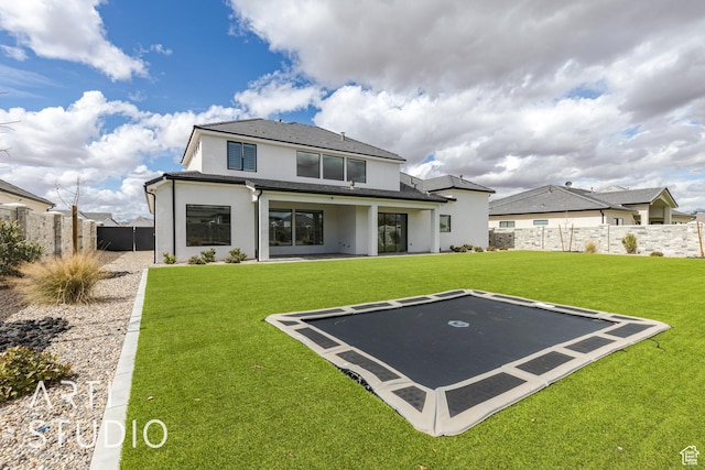 3823 S Kennedy Ln, Washington, UT 84780 - back of property featuring a fenced backyard, stucco siding, a yard, and a trampoline