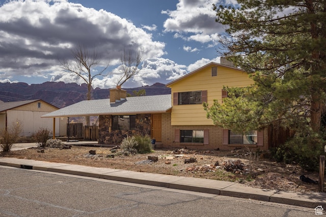 252 Hillside Dr, Moab, UT 84532 - split level home with brick siding, a chimney, and a shingled roof