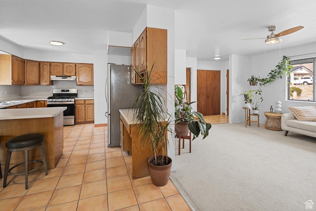 252 Hillside Dr, Moab, UT 84532 - kitchen with brown cabinets, light tile patterned flooring, light countertops, appliances with stainless steel finishes, and open floor plan