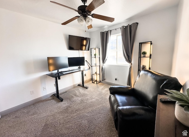 carpeted home office featuring baseboards and ceiling fan