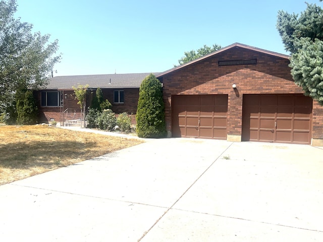 single story home with concrete driveway and brick siding