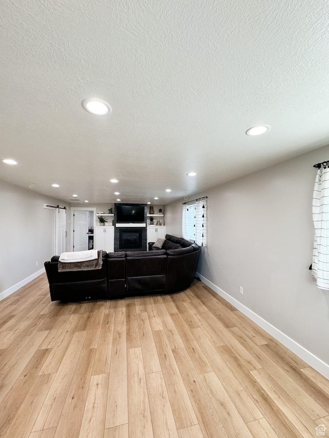 5517 S 6800 W, Hooper, UT 84315 - living room featuring a textured ceiling, recessed lighting, a barn door, light wood-style floors, and baseboards