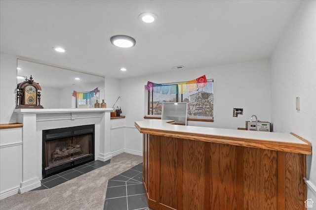 bar with visible vents, baseboards, a fireplace with flush hearth, recessed lighting, and dark colored carpet